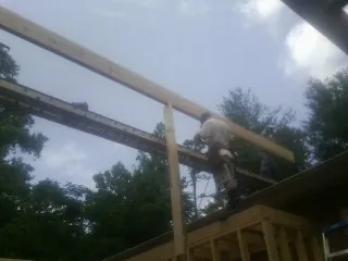 Carpenter setting a ridge beam over a new addition frame — Ice Dam Removal by Roofing Brothers in Sundance