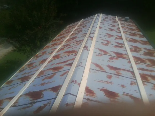 Rusted metal roof panels with new wood purlins before replacement — Storm Damage Roof Repair in Sundance by Roofing Brothers