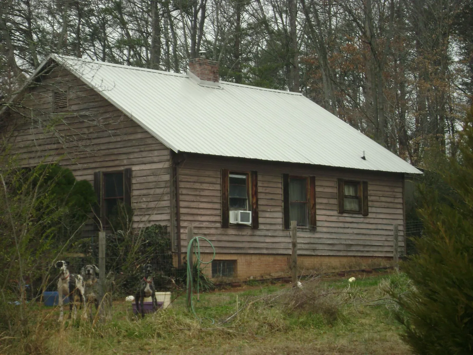 White metal roof on an old wood sided farmhouse, from a Metal Roof Installation job in Sundance